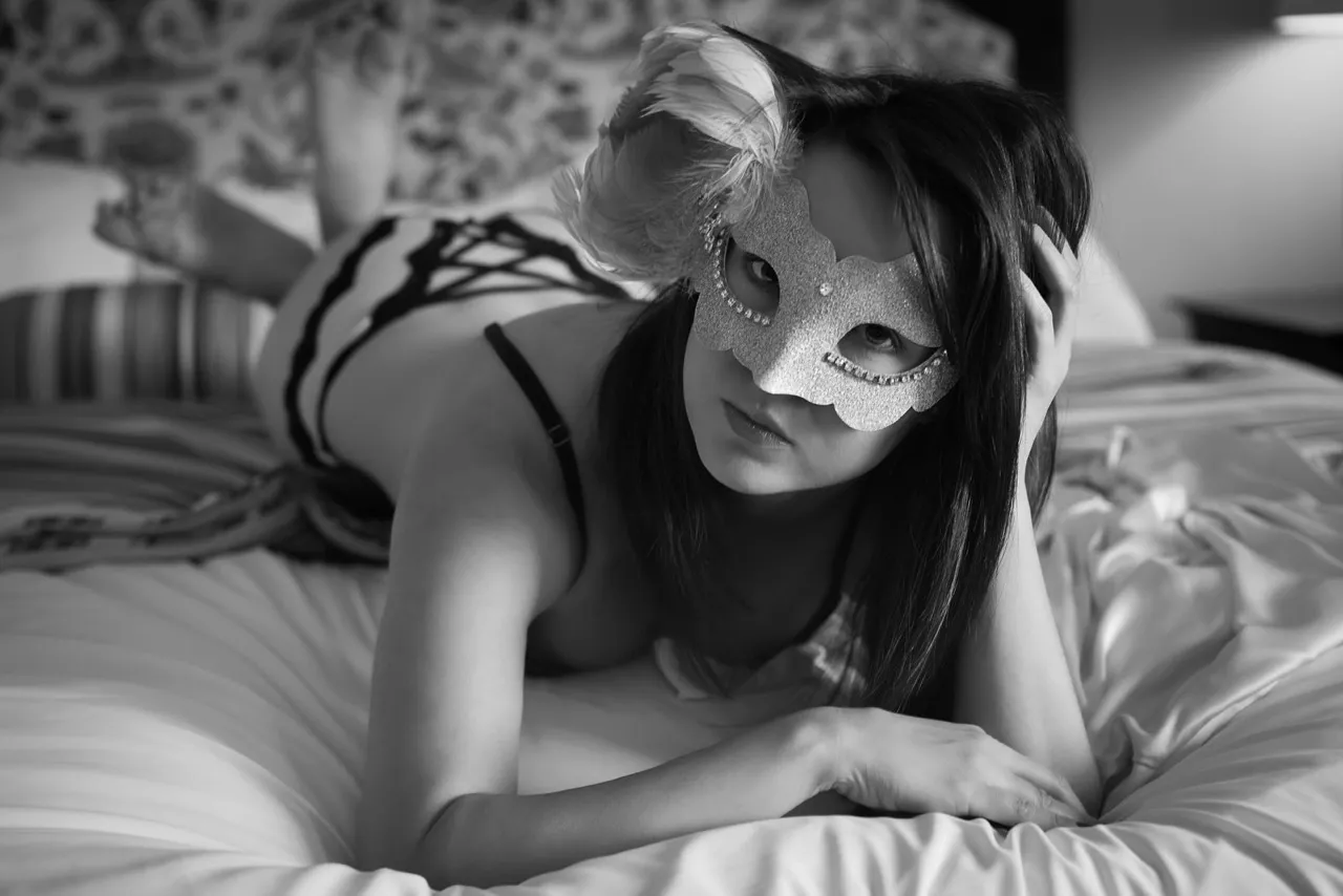 Subtle sensuality: masked boudoir client in pink satin robe